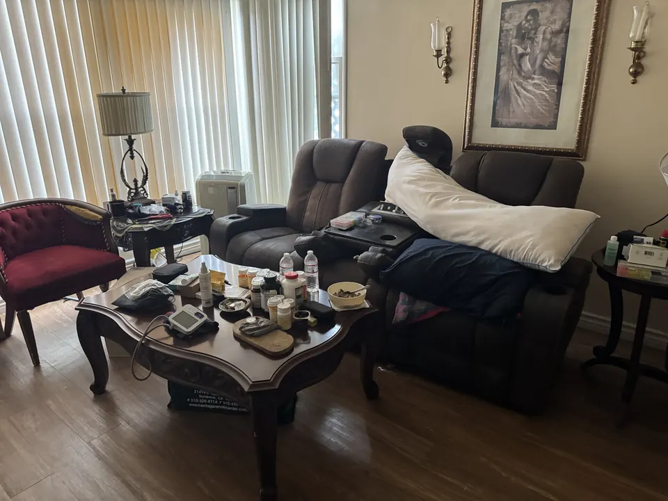 Sofa and household belongings in a living room before scope review; personal items are not an offer of removal