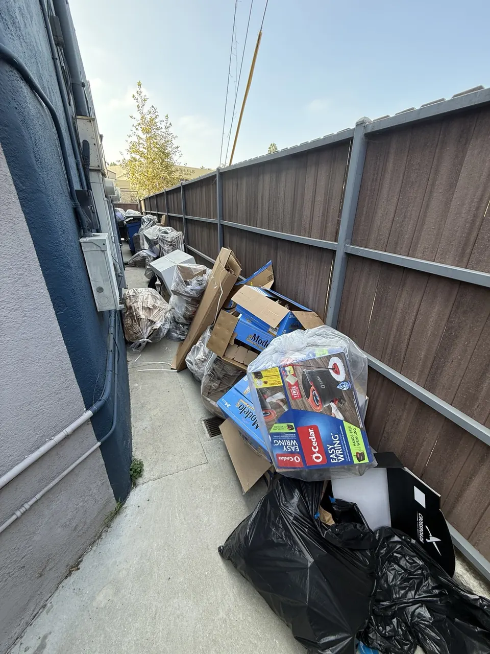 Boxes and bags along a fenced service walkway