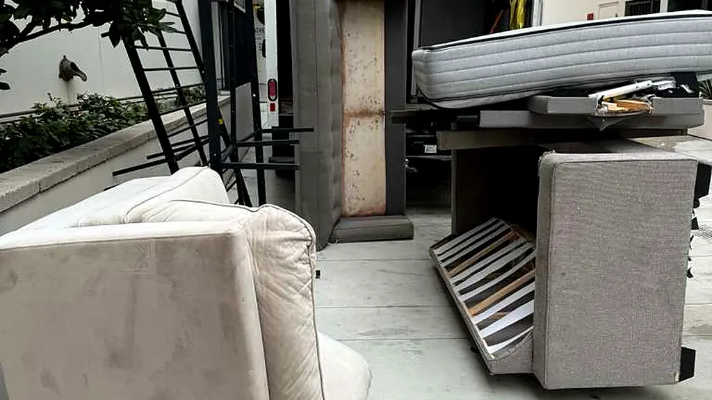 Mattresses, a couch and a bed frame carried out and staged at the loading area during a Baka Junk Removal apartment move-out