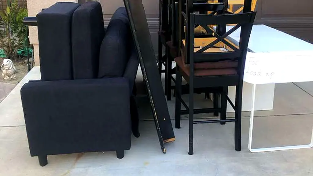 Sofa, dining chairs and a desk staged in a Los Angeles driveway for a Baka Junk Removal curbside furniture pickup