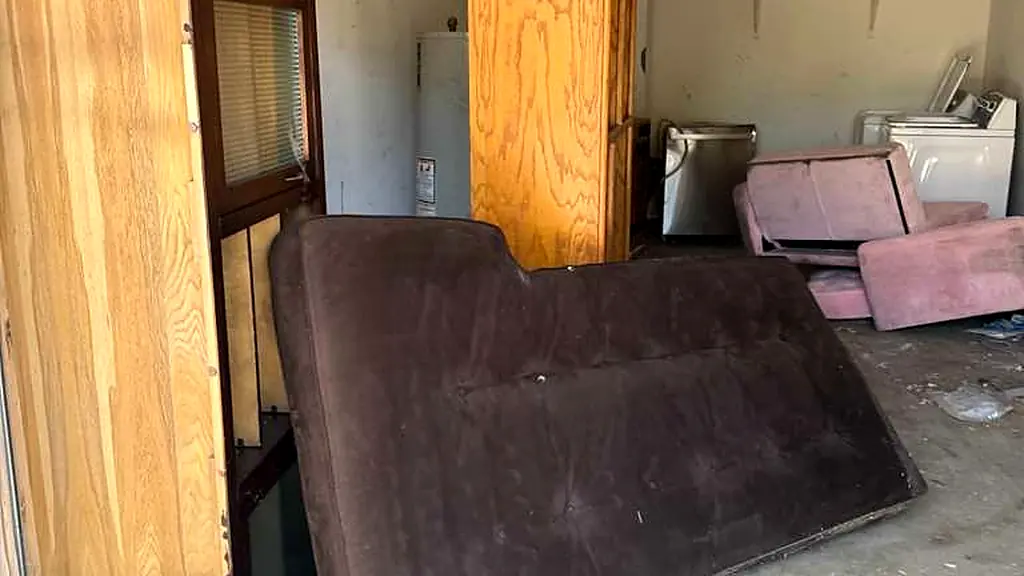 Futon, cabinet doors and old appliances pulled out during a residential garage cleanout in Los Angeles