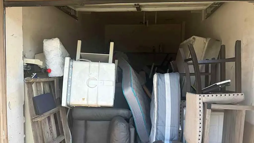 A Los Angeles garage packed floor to ceiling with mattresses, furniture and boxes before a Baka Junk Removal cleanout