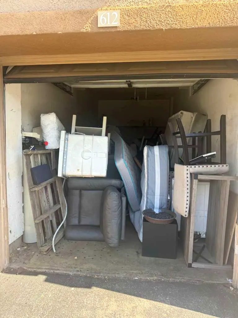 A Los Angeles garage packed floor to ceiling with mattresses, furniture and boxes before a Baka Junk Removal cleanout