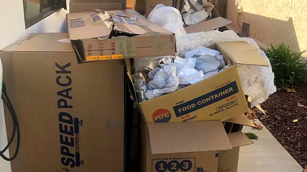 Overflowing moving boxes and packing paper set out at the side of a Los Angeles home for a post-move haul-away
